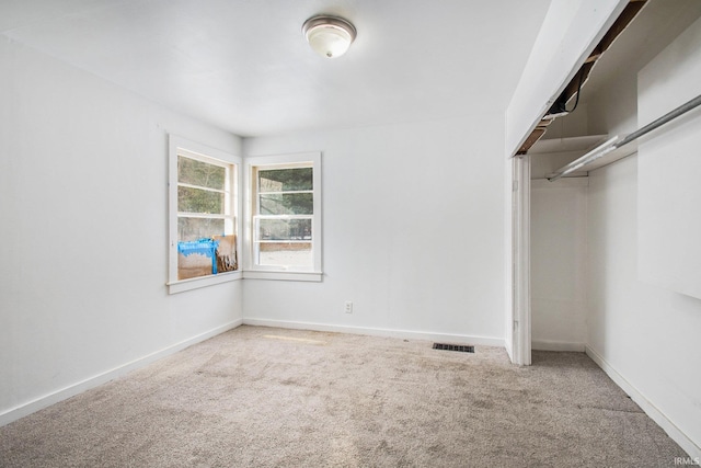 unfurnished bedroom featuring a closet, visible vents, baseboards, and carpet