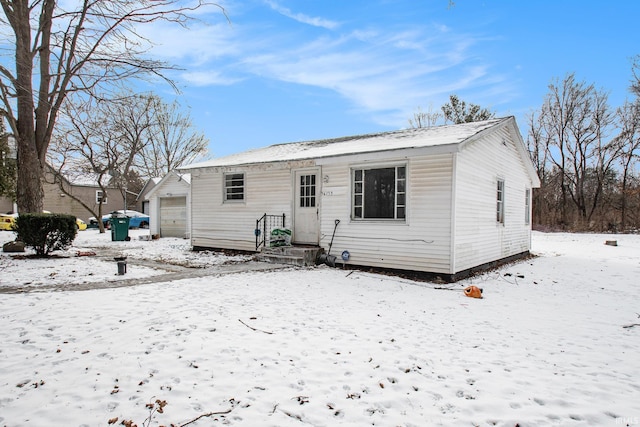 snow covered property with a garage