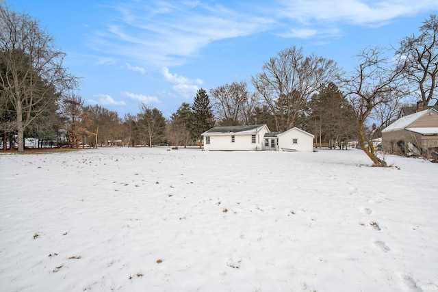 yard layered in snow with an outbuilding