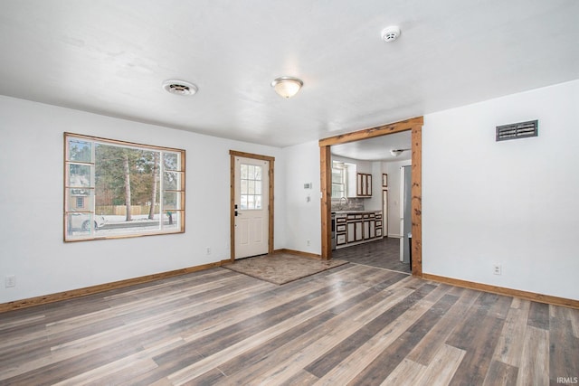 foyer featuring visible vents, baseboards, and wood finished floors