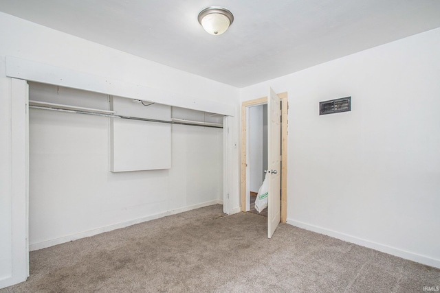 unfurnished bedroom featuring a closet, light carpet, and baseboards