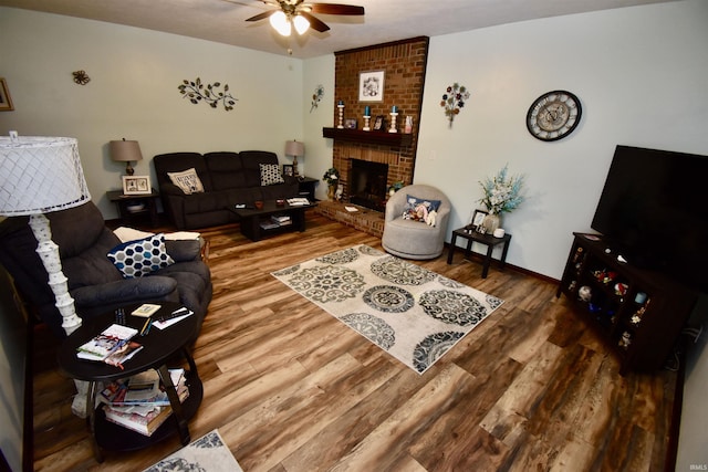 living room featuring a brick fireplace, hardwood / wood-style flooring, and ceiling fan