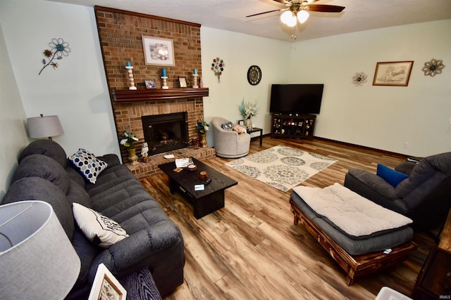 living room featuring ceiling fan, wood-type flooring, and a fireplace