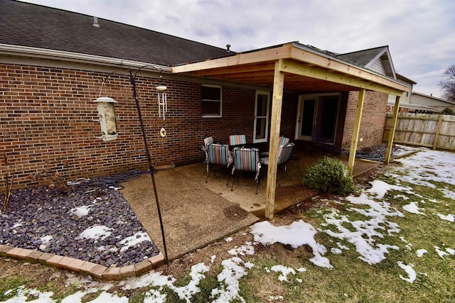 snow covered house with a patio