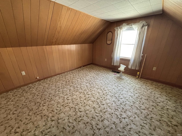 bonus room with lofted ceiling and wooden walls