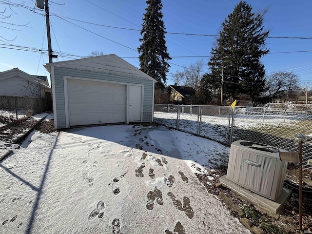 snow covered garage with central AC unit