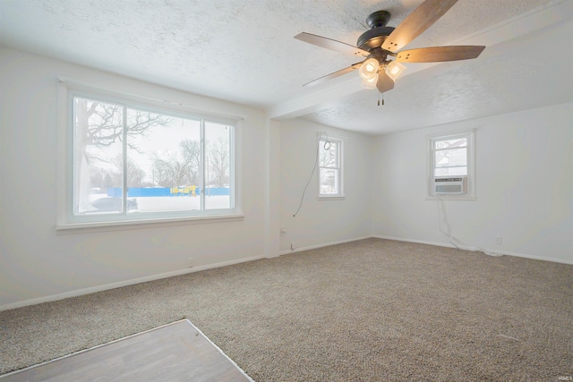 carpeted spare room featuring ceiling fan and a textured ceiling