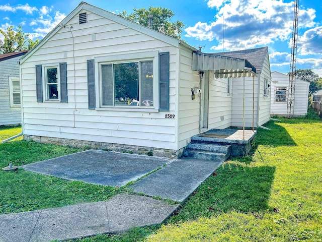 view of front of house with a front lawn and a patio area