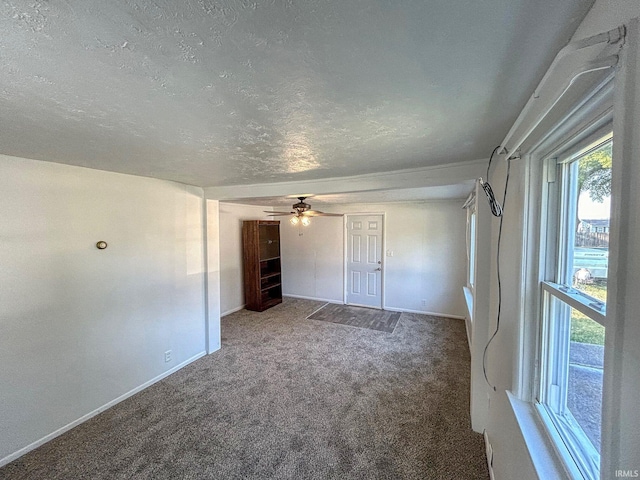 interior space with ceiling fan, a textured ceiling, and carpet flooring