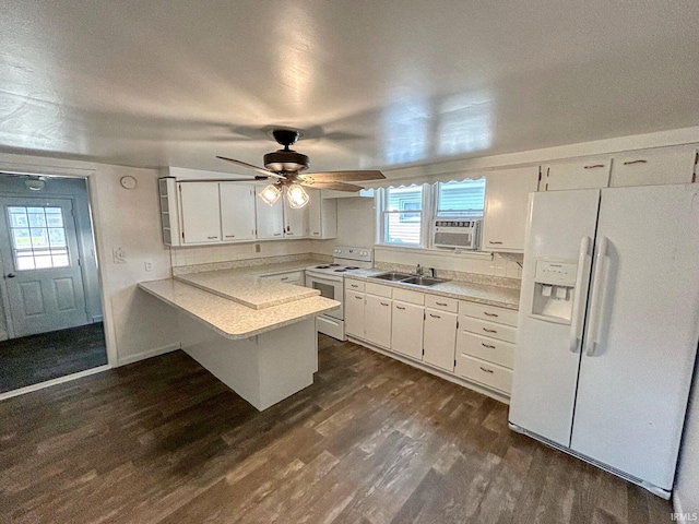 kitchen with sink, white cabinets, dark hardwood / wood-style flooring, kitchen peninsula, and white appliances