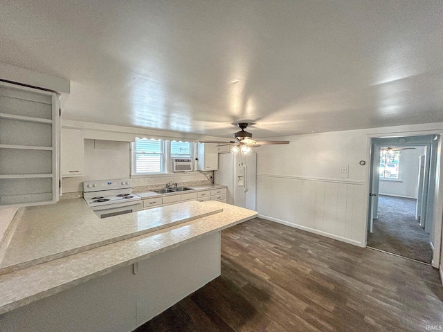 kitchen featuring sink, white electric range, plenty of natural light, white cabinets, and kitchen peninsula