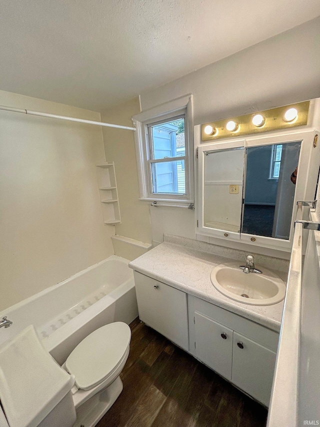 full bathroom featuring toilet, tub / shower combination, a textured ceiling, vanity, and hardwood / wood-style flooring