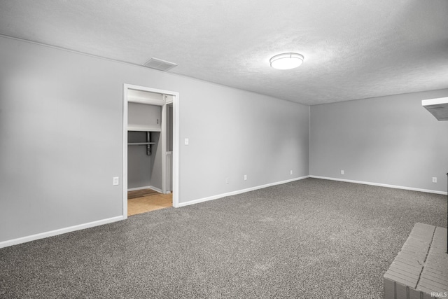 unfurnished bedroom with a spacious closet, a textured ceiling, and carpet flooring