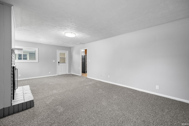 unfurnished living room featuring carpet floors and a textured ceiling