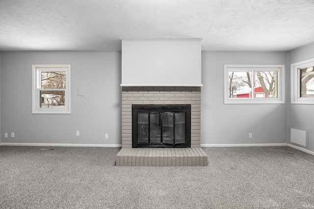 unfurnished living room with a fireplace, plenty of natural light, and carpet flooring