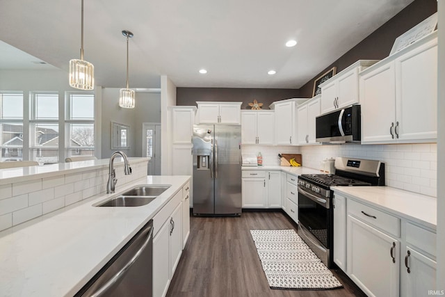 kitchen featuring light countertops, appliances with stainless steel finishes, a sink, and white cabinets