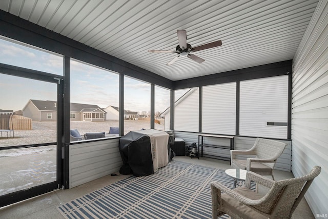 sunroom / solarium featuring ceiling fan and a residential view