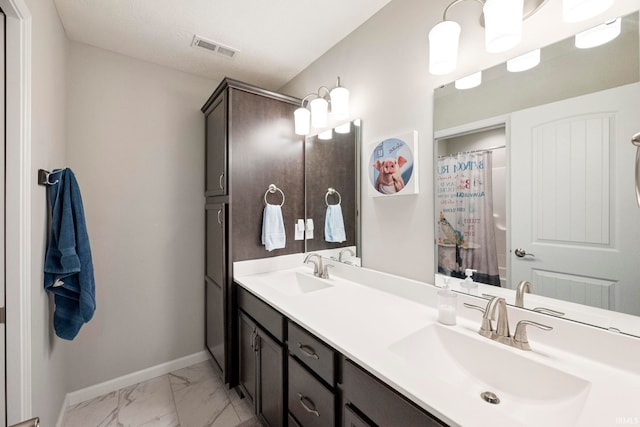 bathroom featuring marble finish floor, visible vents, a sink, and baseboards