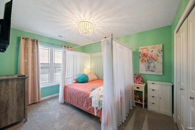 bedroom with light colored carpet, visible vents, a textured ceiling, a chandelier, and baseboards