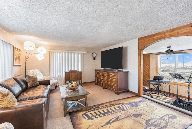 living room featuring ceiling fan, carpet flooring, and a textured ceiling