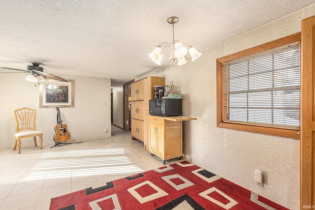 kitchen featuring light tile patterned floors, ceiling fan with notable chandelier, and decorative light fixtures