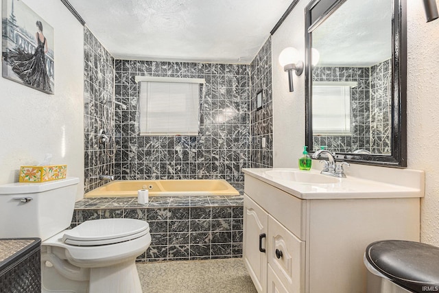 full bathroom featuring tiled shower / bath combo, vanity, a textured ceiling, and toilet