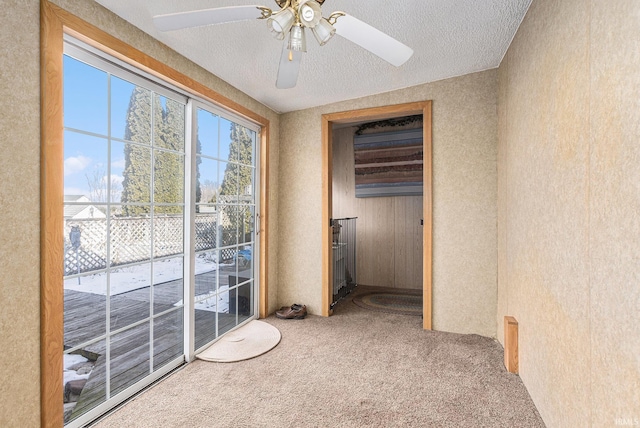 interior space featuring carpet floors, a textured ceiling, and ceiling fan