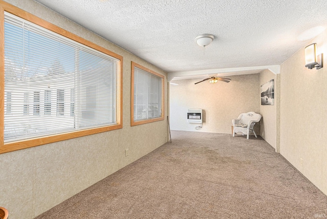 hallway with carpet, heating unit, and a textured ceiling