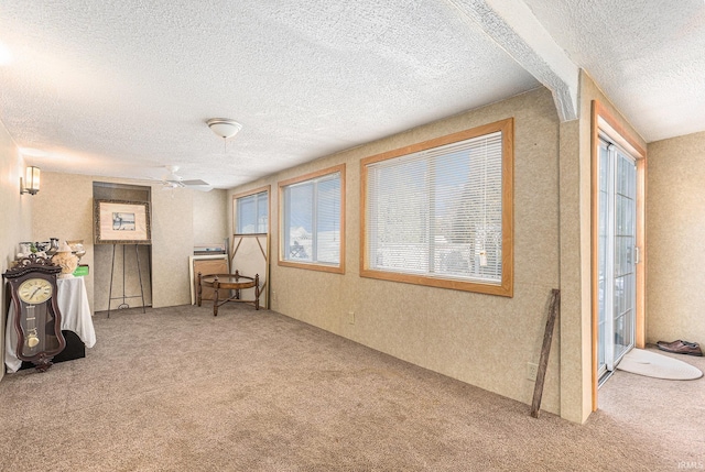 living area with a textured ceiling and carpet