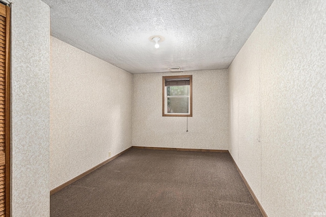 spare room featuring carpet flooring and a textured ceiling