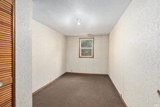 carpeted spare room featuring a textured ceiling