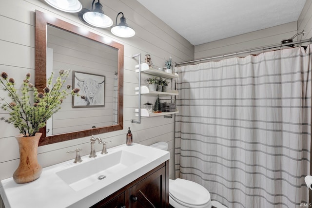 bathroom featuring vanity, walk in shower, wooden walls, and toilet