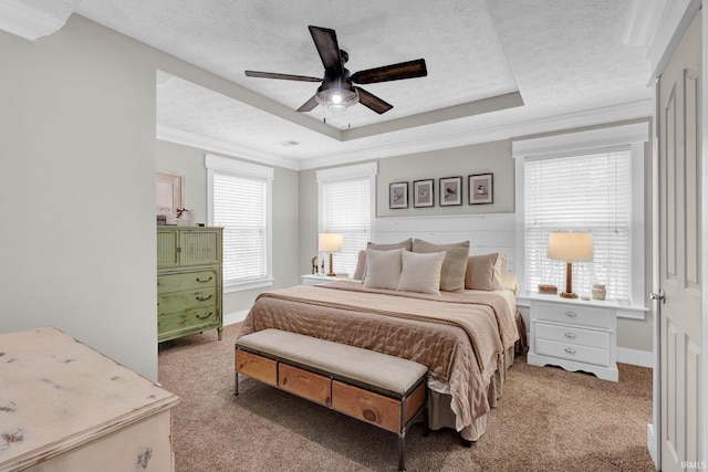 bedroom with ceiling fan, a tray ceiling, crown molding, light carpet, and a textured ceiling