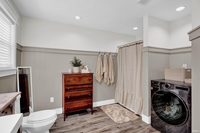 clothes washing area featuring washer / clothes dryer and light hardwood / wood-style flooring