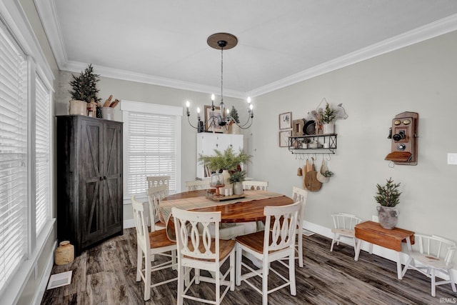 dining space with crown molding, wood-type flooring, and a notable chandelier