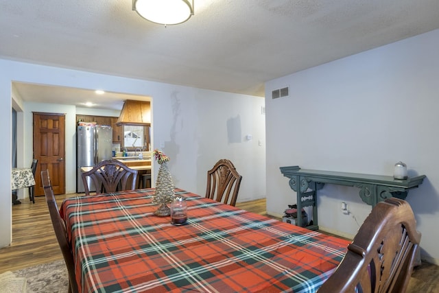 dining space with dark hardwood / wood-style flooring and a textured ceiling