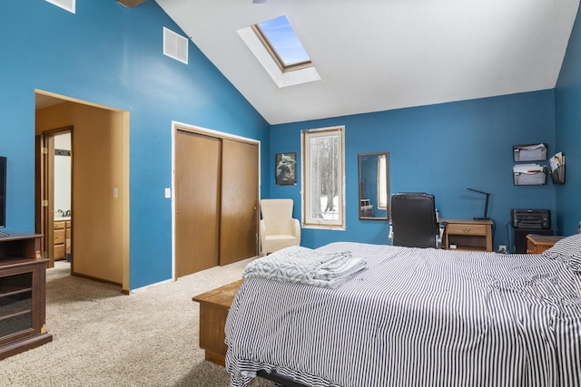 bedroom featuring lofted ceiling with skylight, light carpet, and a closet