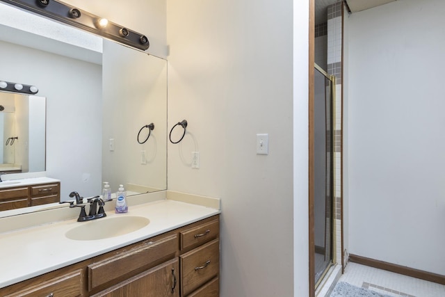 bathroom featuring a shower with door and vanity