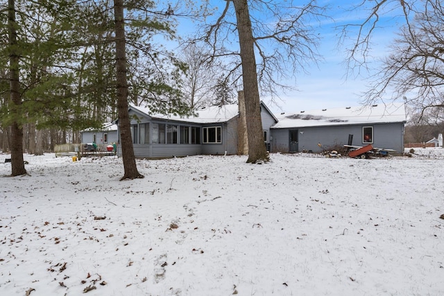 snow covered property featuring a sunroom