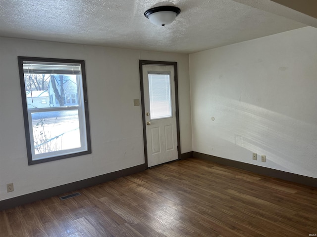 foyer with dark hardwood / wood-style flooring and a textured ceiling