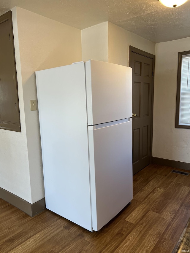 kitchen featuring dark wood-type flooring, a textured ceiling, and white refrigerator