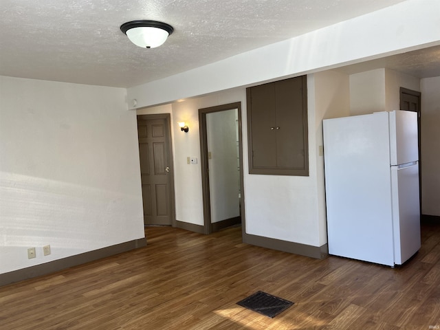 unfurnished room with dark wood-type flooring and a textured ceiling