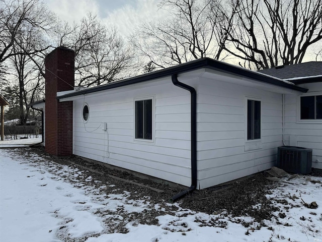 view of snowy exterior with central air condition unit