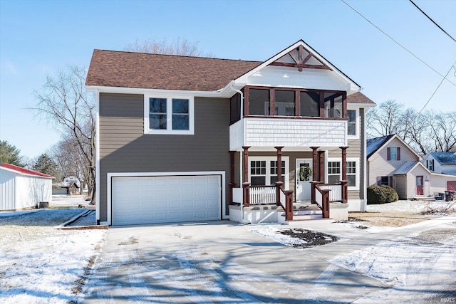 view of front facade with a garage, covered porch, and a sunroom