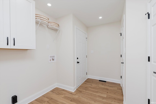 clothes washing area with hookup for a washing machine and light hardwood / wood-style floors