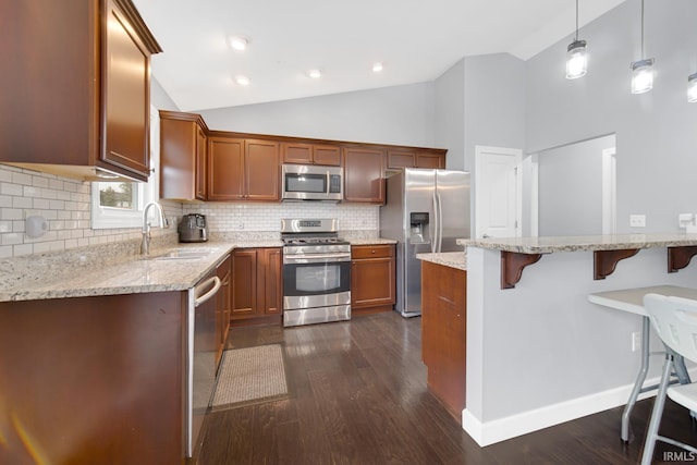 kitchen with pendant lighting, sink, appliances with stainless steel finishes, light stone counters, and tasteful backsplash