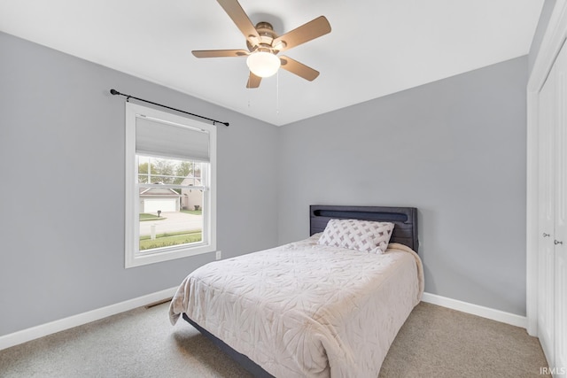 bedroom featuring light carpet, ceiling fan, and a closet