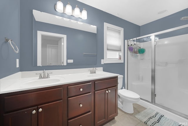 bathroom featuring tile patterned flooring, vanity, an enclosed shower, and toilet