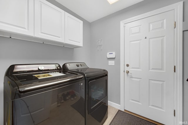 clothes washing area featuring cabinets and separate washer and dryer