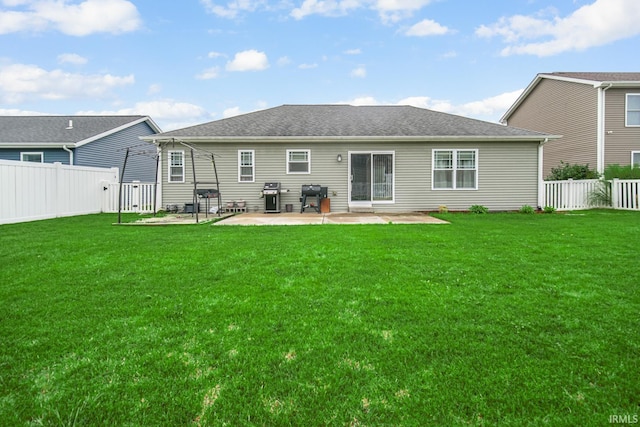 rear view of house featuring a lawn and a patio